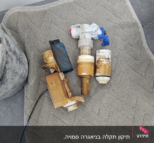 חלקי צנרת וכלים על שטיח אפור